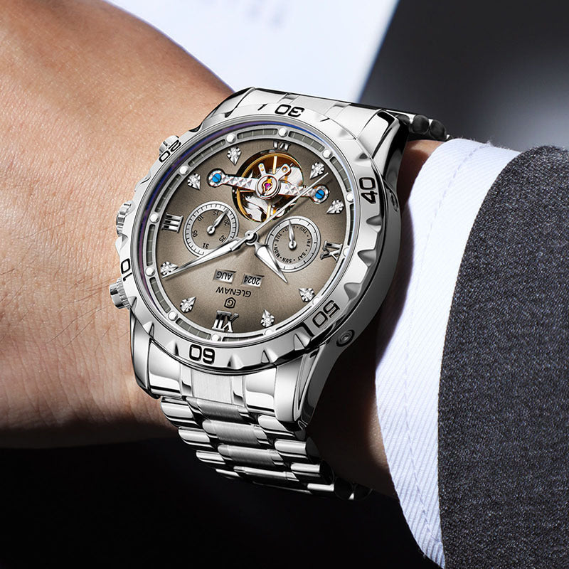 Silver wristwatch with a detailed face on a person's wrist.