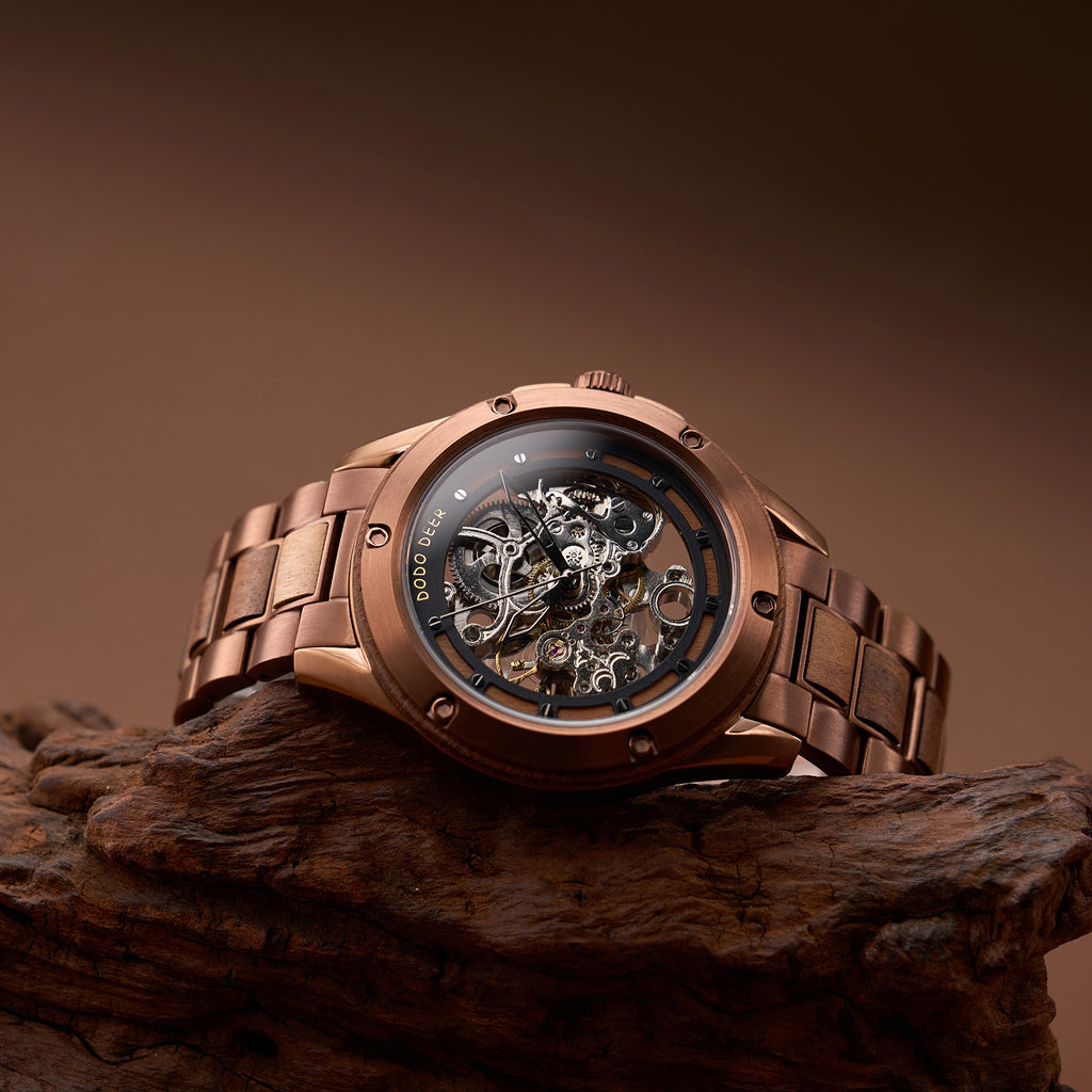 Bronze wristwatch with visible mechanical components on a wooden surface