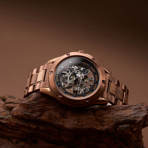 Bronze wristwatch with visible mechanical components on a wooden surface