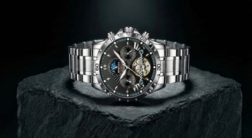 Silver wristwatch with intricate design on a dark background