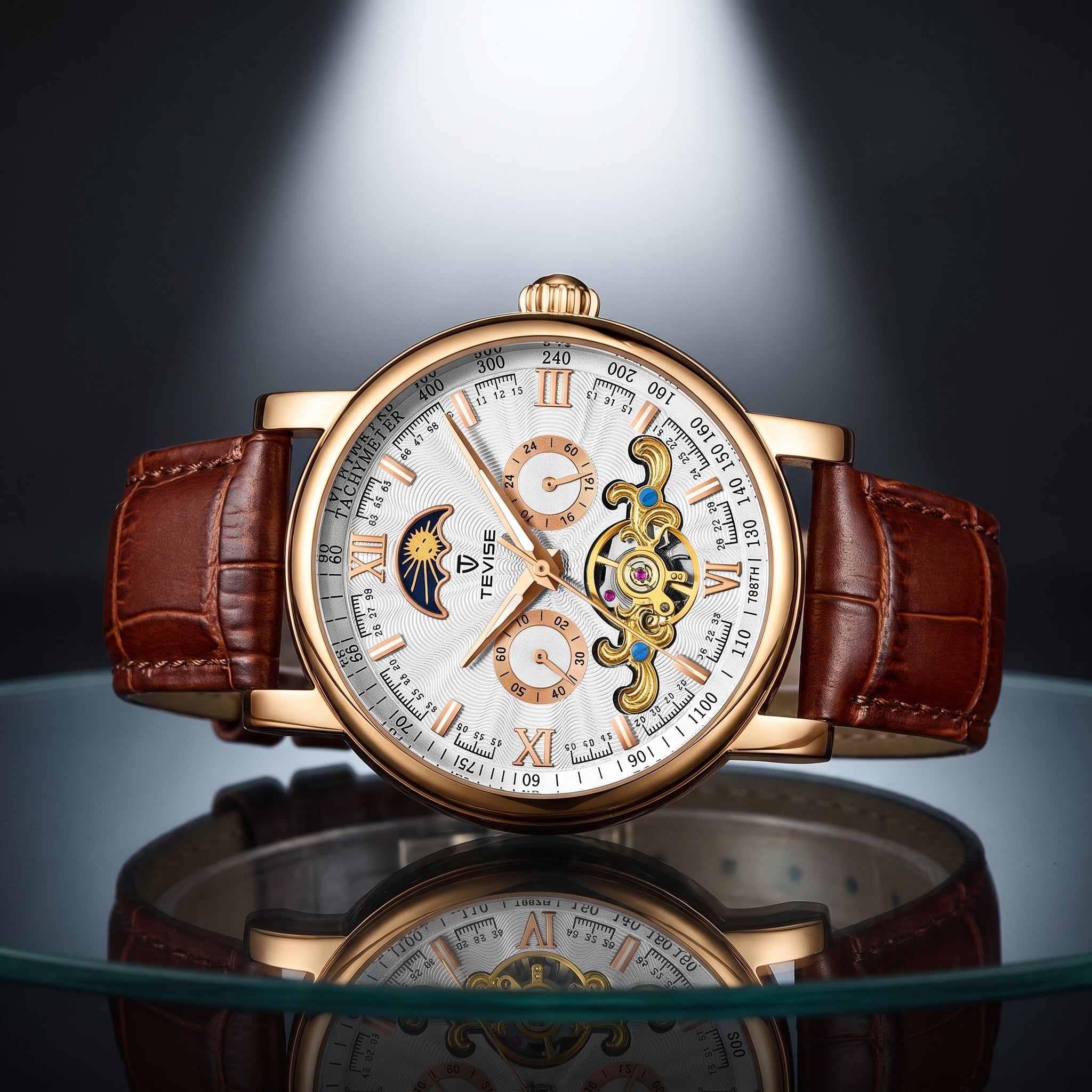 A luxury wristwatch with a gold-tone case, white dial, brown leather strap, and visible skeletonized mechanical movement, displayed on a reflective surface against a dark studio background.