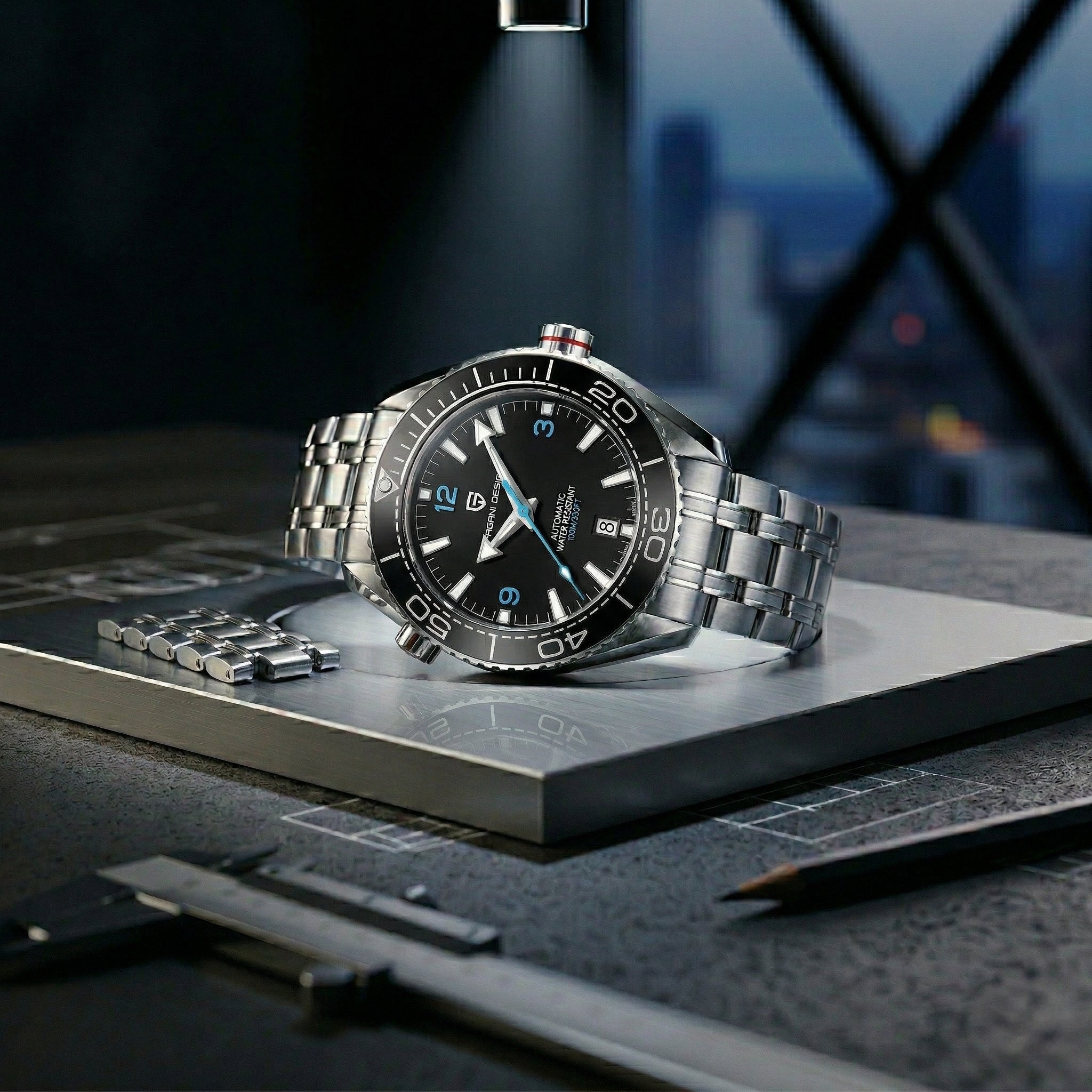 Silver watch with black dial on a metallic surface with a blurred cityscape background