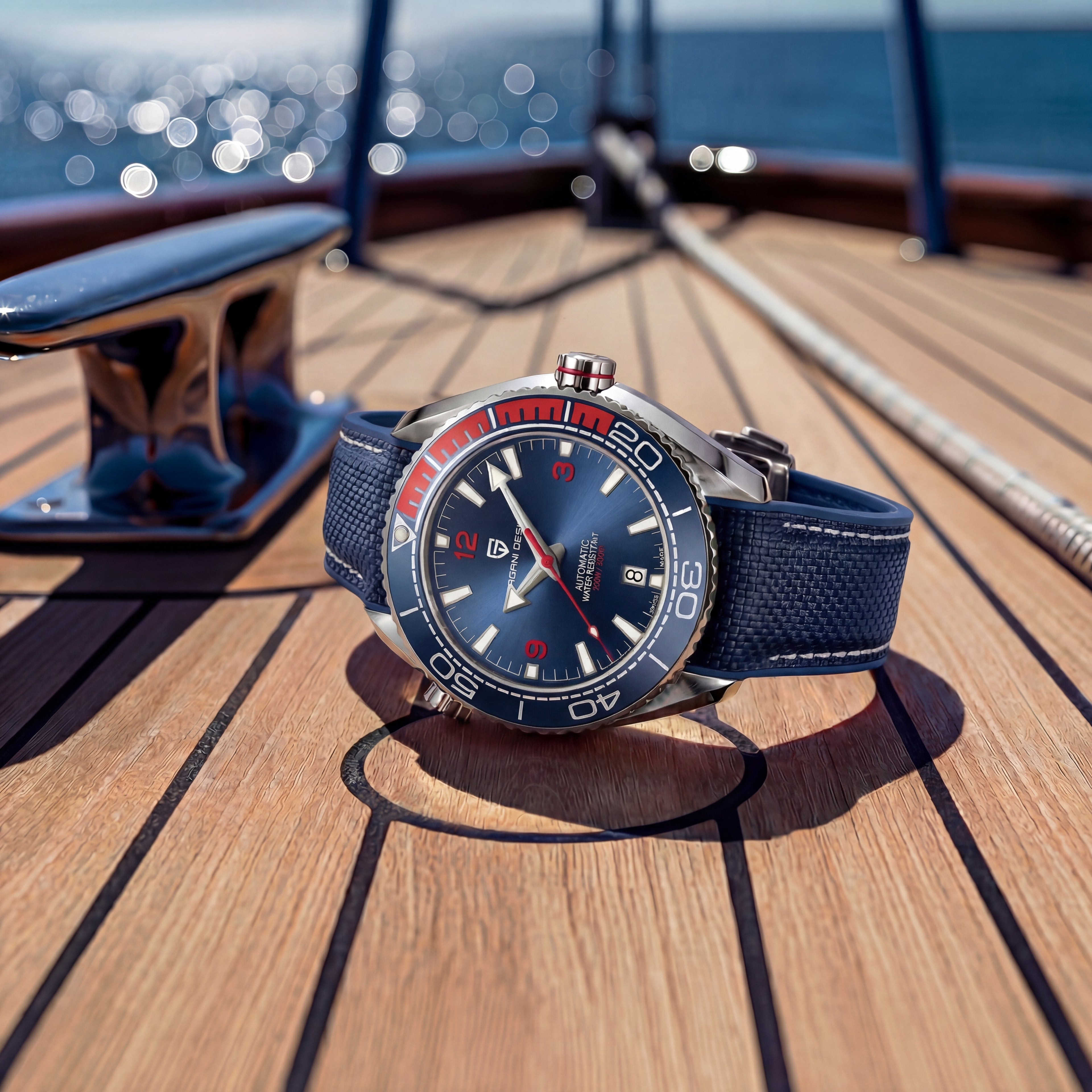 Watch with a blue strap and silver case on a wooden deck with ocean view