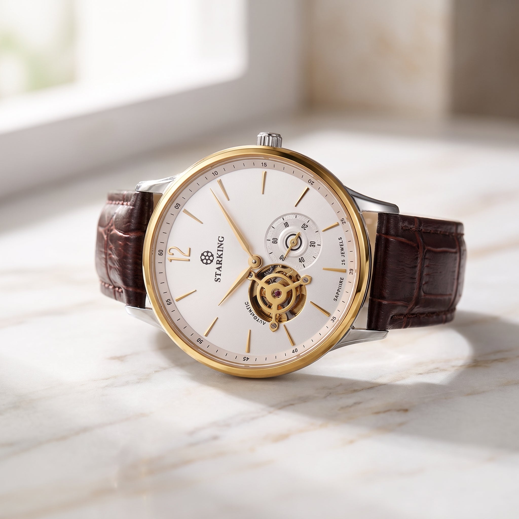 A luxury wristwatch with a white dial, gold-tone case, and brown alligator-textured leather strap, resting on a light marble surface.