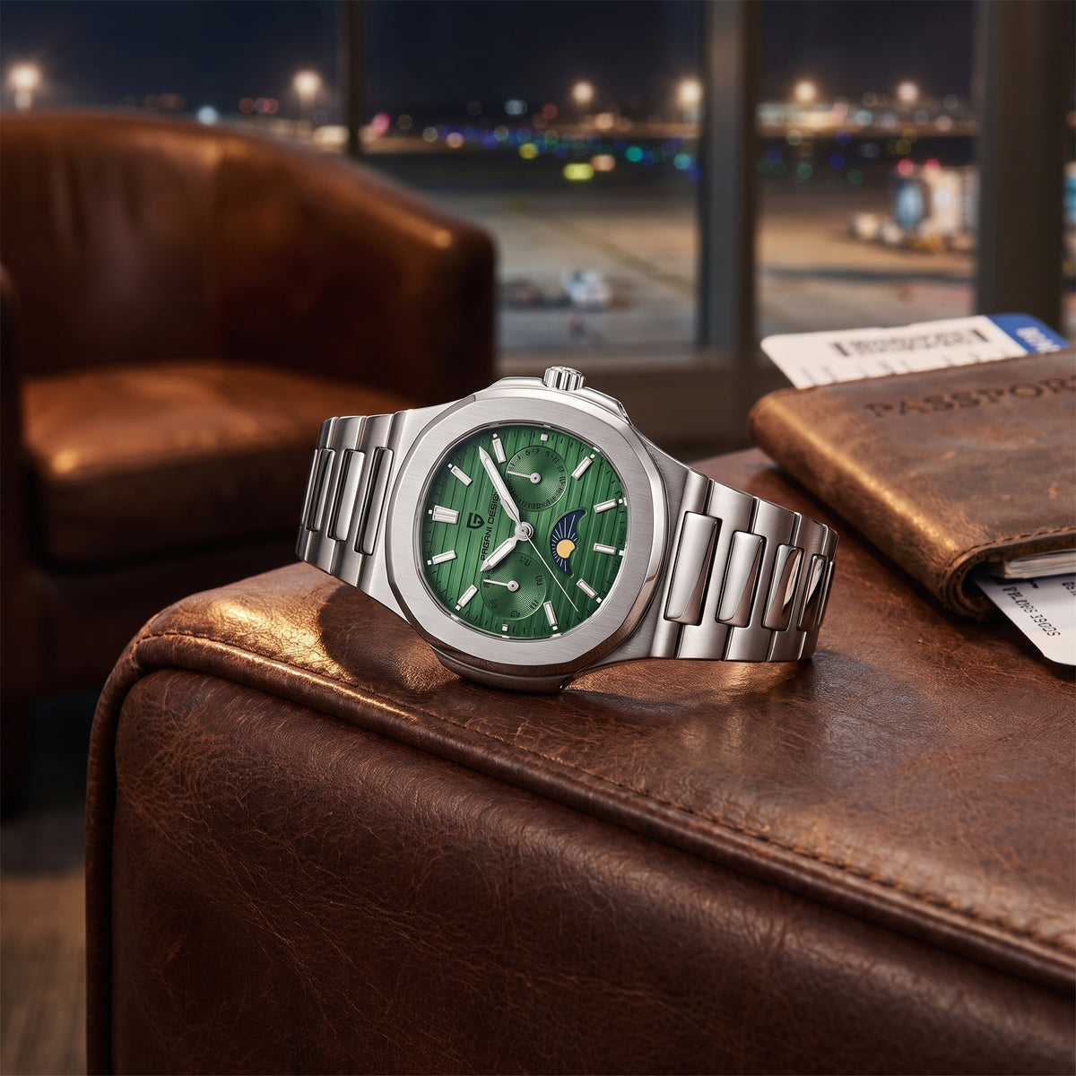 A silver stainless steel watch with a green malachite-pattern dial rests on a brown leather armchair in an airport lounge, with a passport and bag nearby and a blurred airport tarmac scene visible through the window behind.